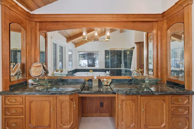 a bathroom with a granite countertop sink and a large mirror