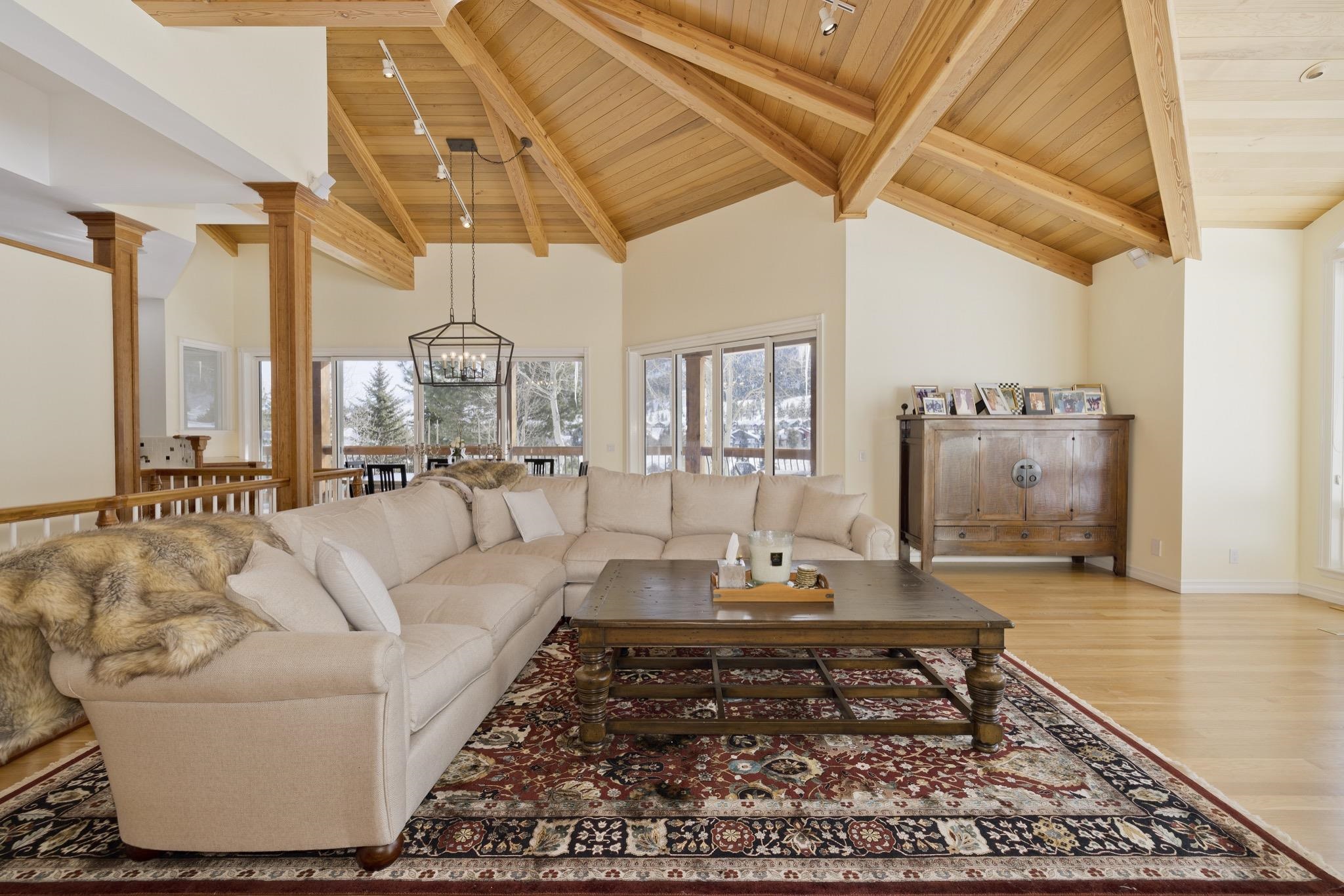 370 Ranch Road Mammoth Lakes, CA 93546 - Photo 5 of 46 Living area with a wooden ceiling with exposed beams, light wood-style floors, high vaulted ceiling, decorative columns, and a chandelier
