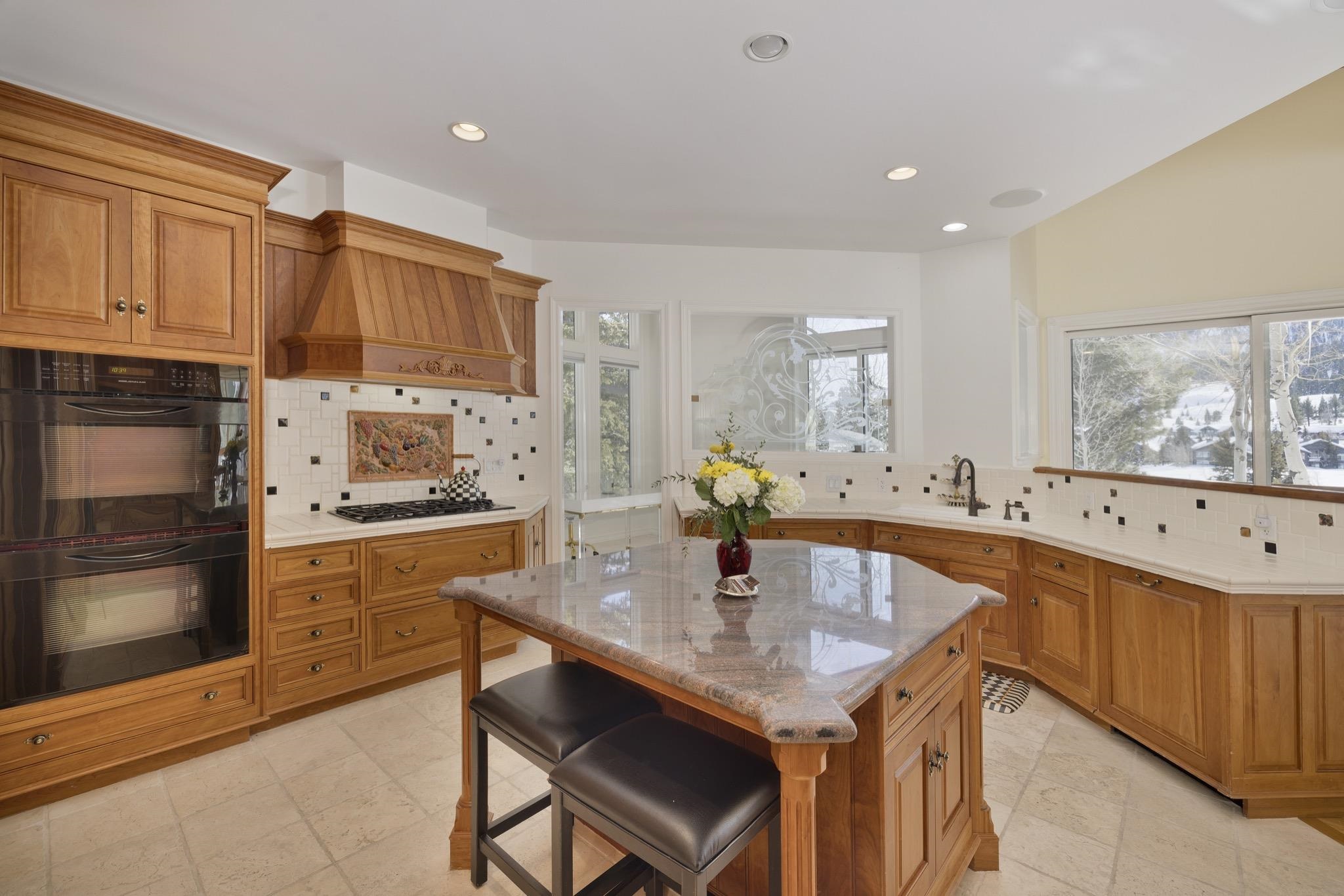 370 Ranch Road Mammoth Lakes, CA 93546 - Photo 9 of 46 Kitchen with brown cabinets, tasteful backsplash, black appliances, and recessed lighting