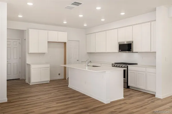 a kitchen with a sink window and stainless steel appliances