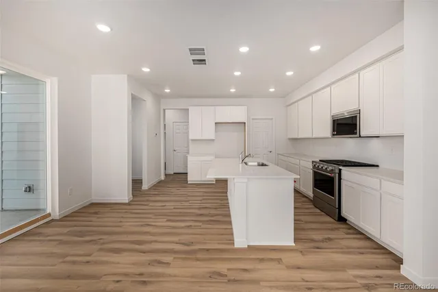 a large kitchen with stainless steel appliances granite countertop a stove and a sink