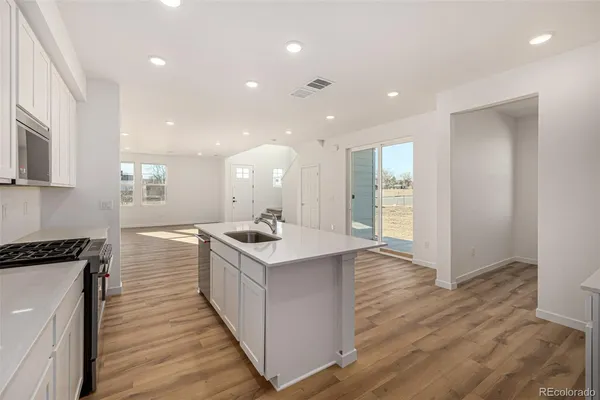 a kitchen with a sink and wooden floor