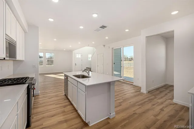 a kitchen with a sink and wooden floor