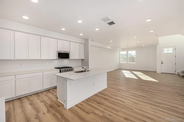 a kitchen with granite countertop white cabinets and white appliances