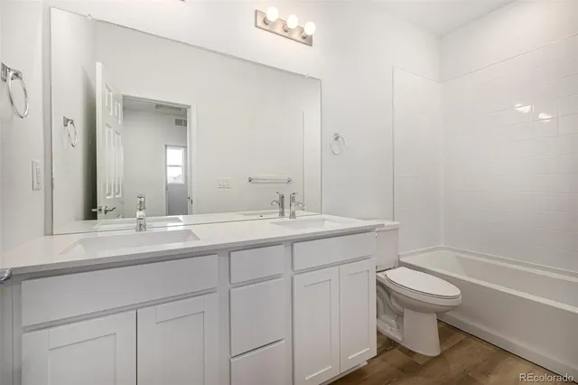 a view of hallway with wooden floor and a sink