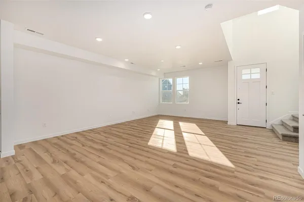 a view of empty room with wooden floor