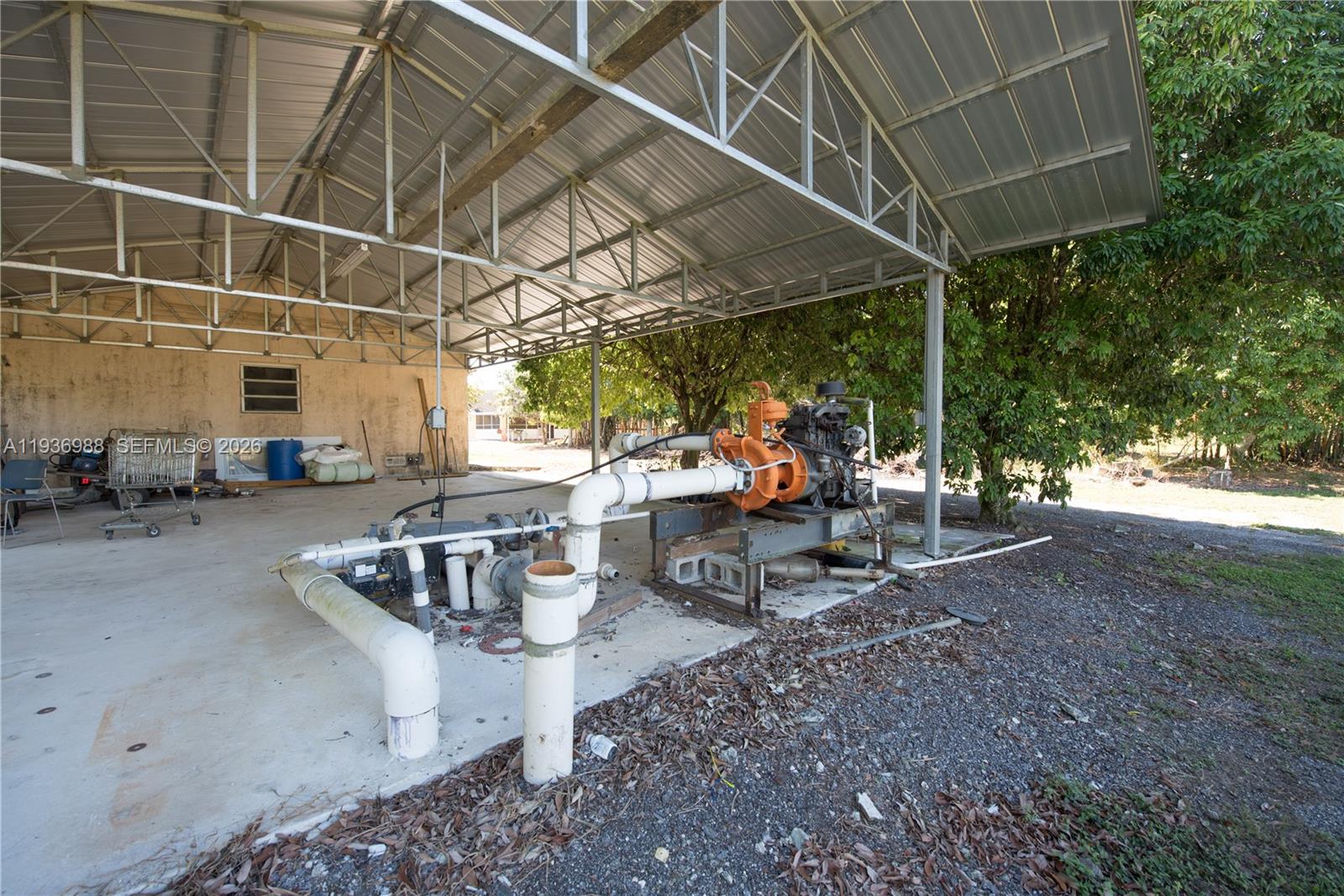 21295 Southwest 376th Street Homestead, FL 33034 - Photo 28 of 51 a view of a patio with table and chairs under an umbrella