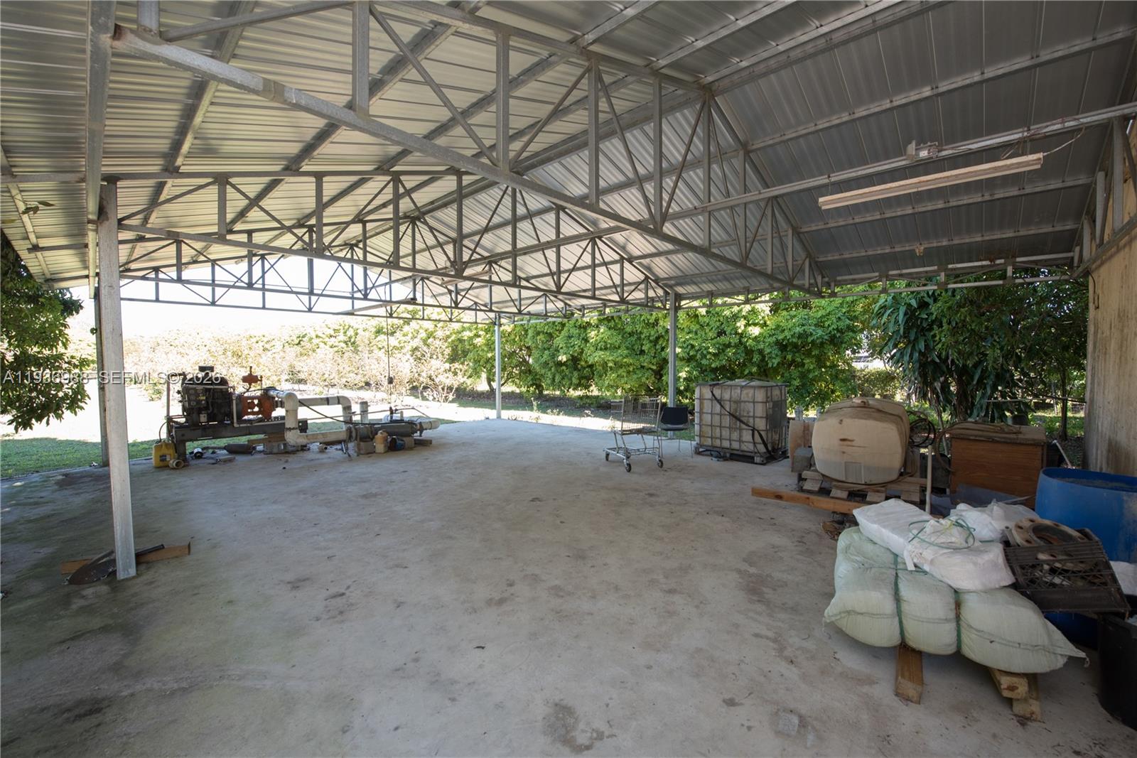 21295 Southwest 376th Street Homestead, FL 33034 - Photo 31 of 51 a view of a patio with table and chairs and couches with wooden floor and fence