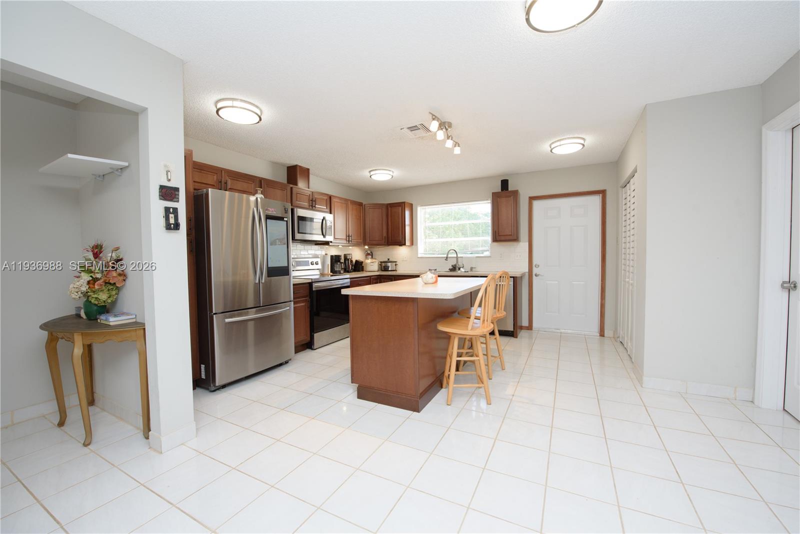 21295 Southwest 376th Street Homestead, FL 33034 - Photo 9 of 51 a kitchen with stainless steel appliances a refrigerator sink and microwave