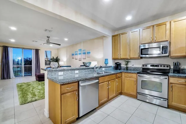 a kitchen with stainless steel appliances granite countertop a stove a sink and a microwave