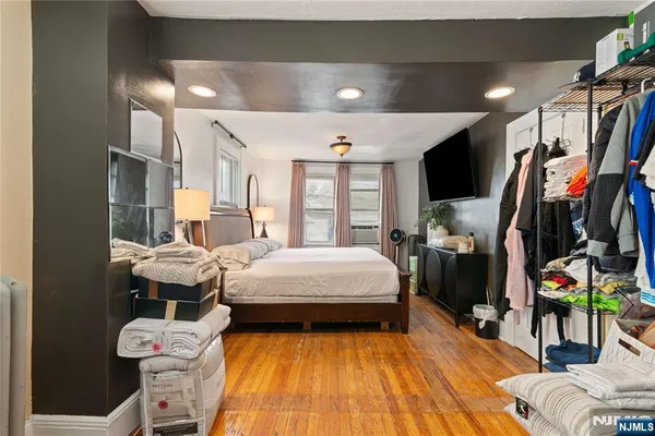 a bedroom with a bed a flat screen tv and dresser