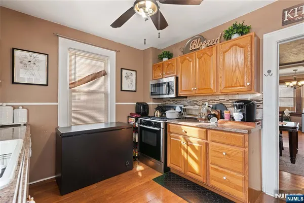 a kitchen with stainless steel appliances granite countertop a stove a sink dishwasher and a microwave oven with cabinets
