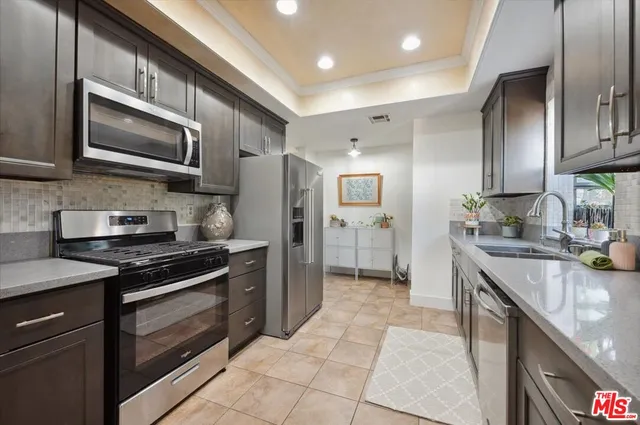 a kitchen with stainless steel appliances granite countertop a stove refrigerator and microwave
