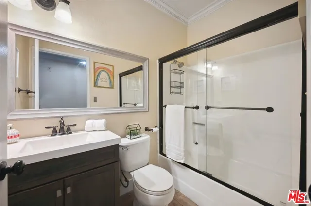 a bathroom with a sink a toilet a mirror and shower