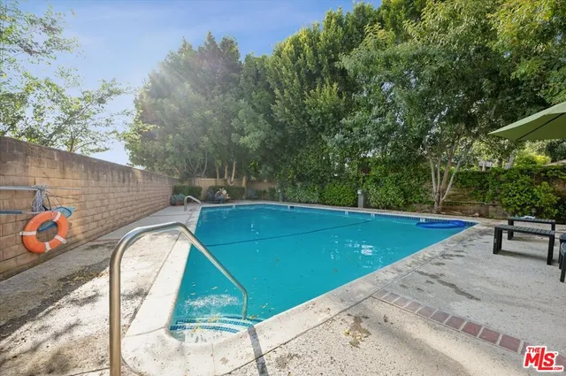 a view of a swimming pool with a patio and a tub
