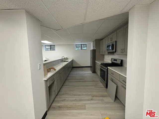 a kitchen with granite countertop white cabinets and stainless steel appliances