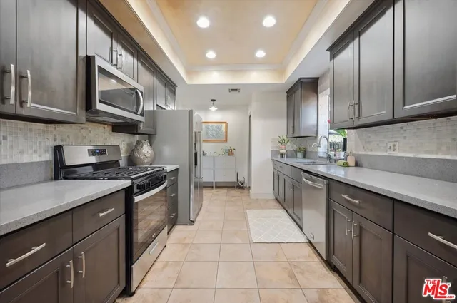 a large kitchen with stainless steel appliances granite countertop a stove a sink and a refrigerator