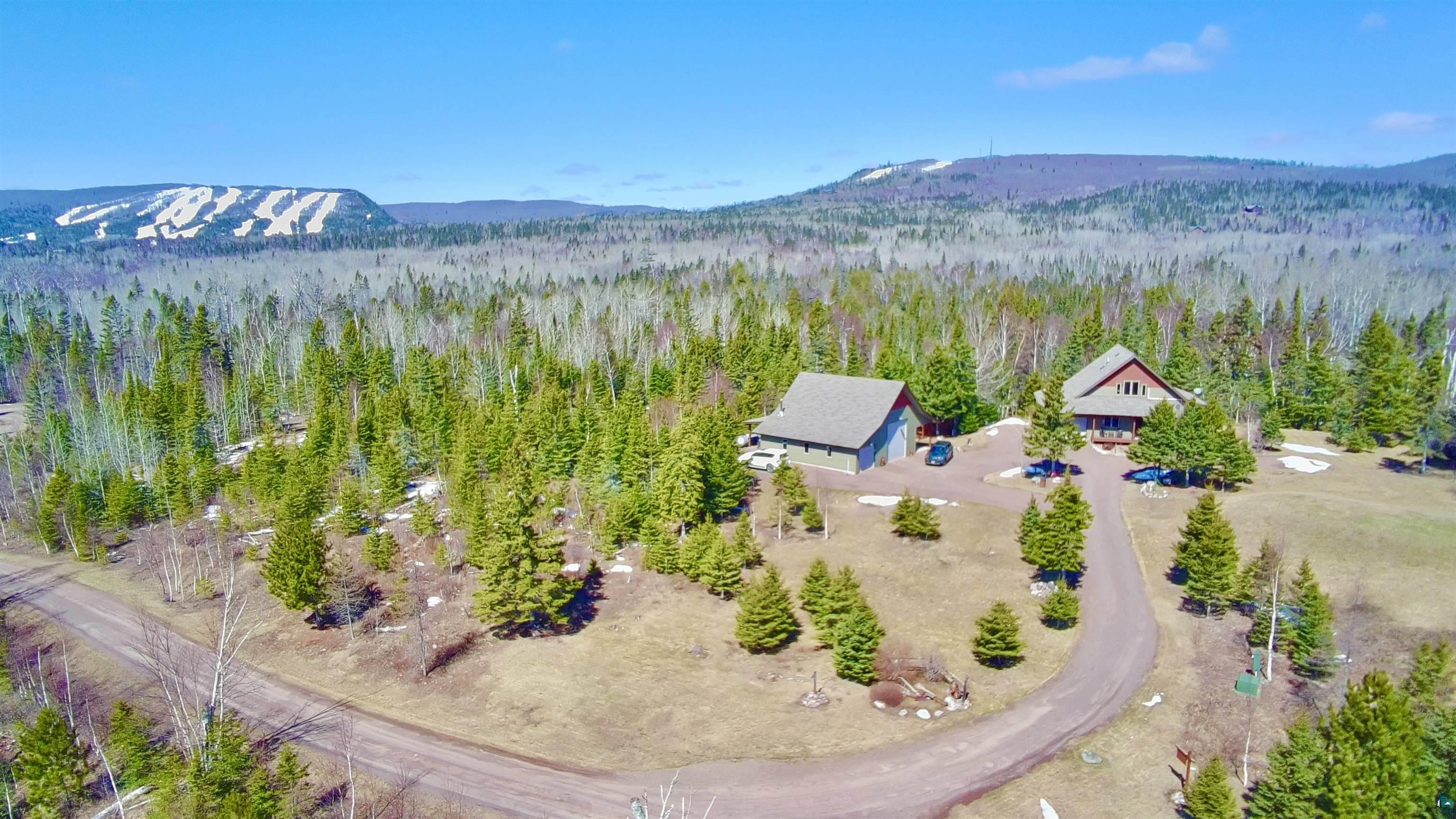 21 Turnagain Trail Lutsen, MN 55612 - Photo 1 of 77 Two distinct residential structures nestled within a dense forest of evergreen trees