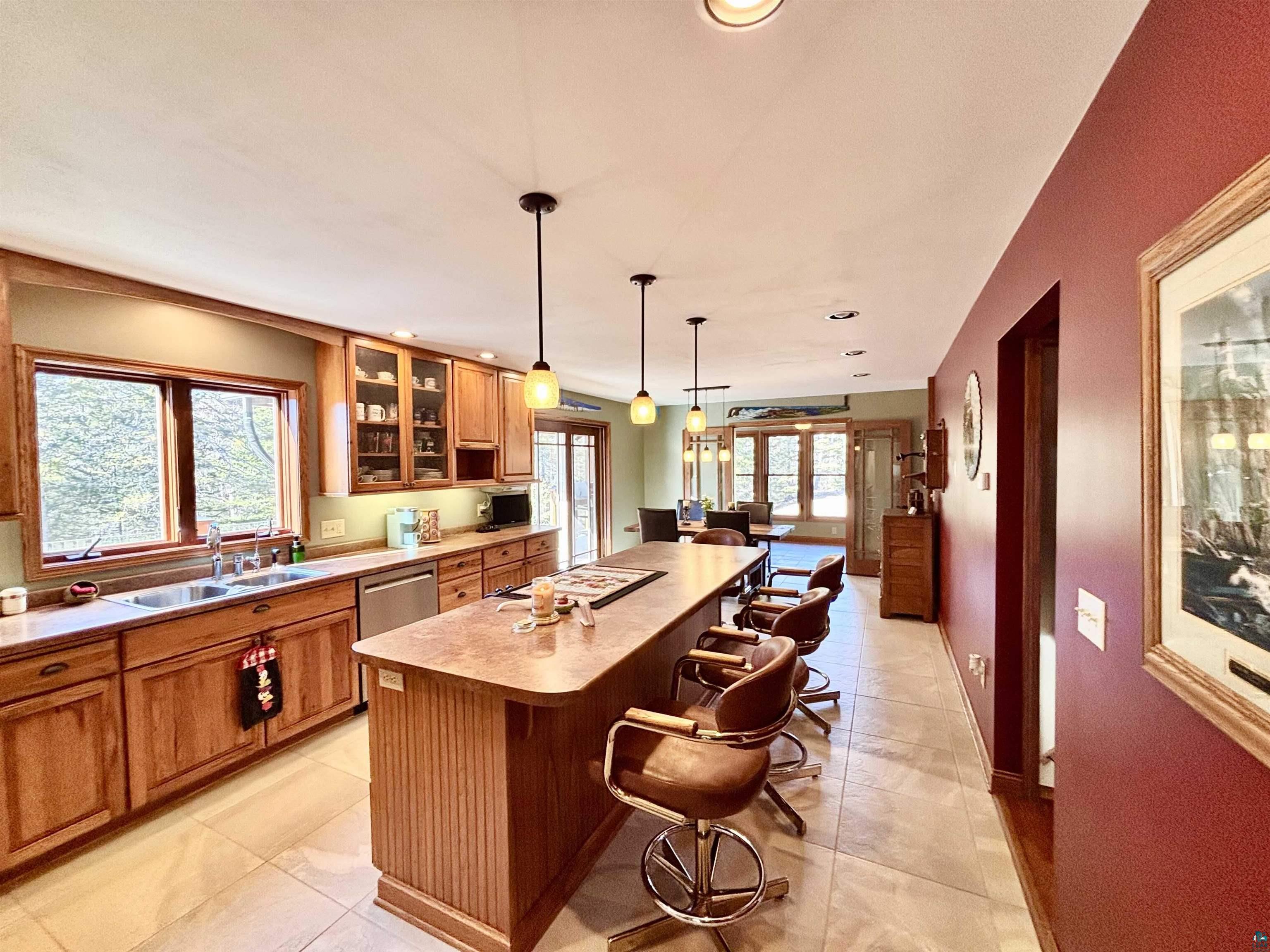 21 Turnagain Trail Lutsen, MN 55612 - Photo 13 of 77 Kitchen featuring extensive wood cabinetry, an island with bar seating, and tile flooring
