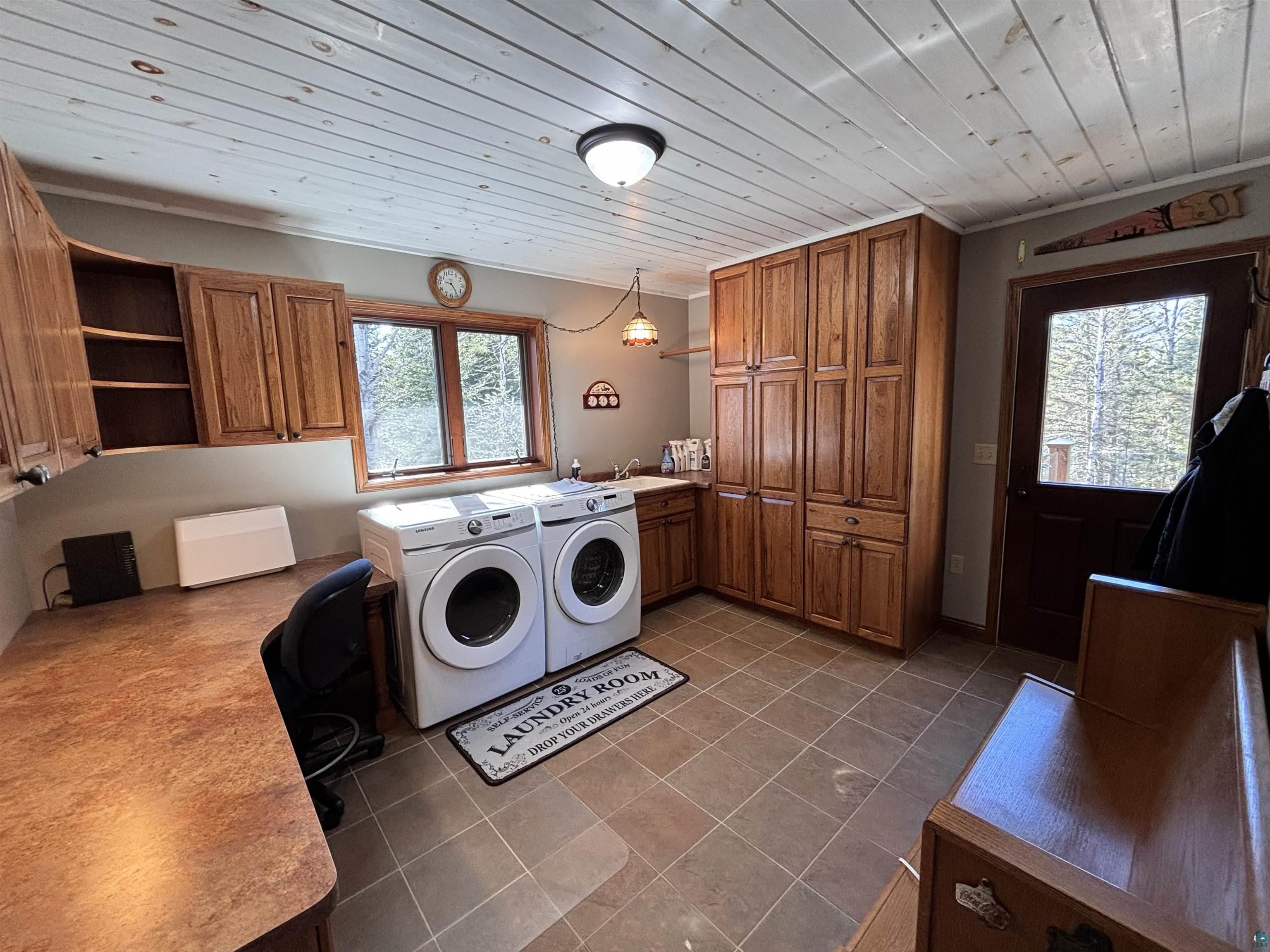 21 Turnagain Trail Lutsen, MN 55612 - Photo 15 of 77 Spacious utility room featuring wood-finish cabinetry, a dedicated workstation, and large transom windows