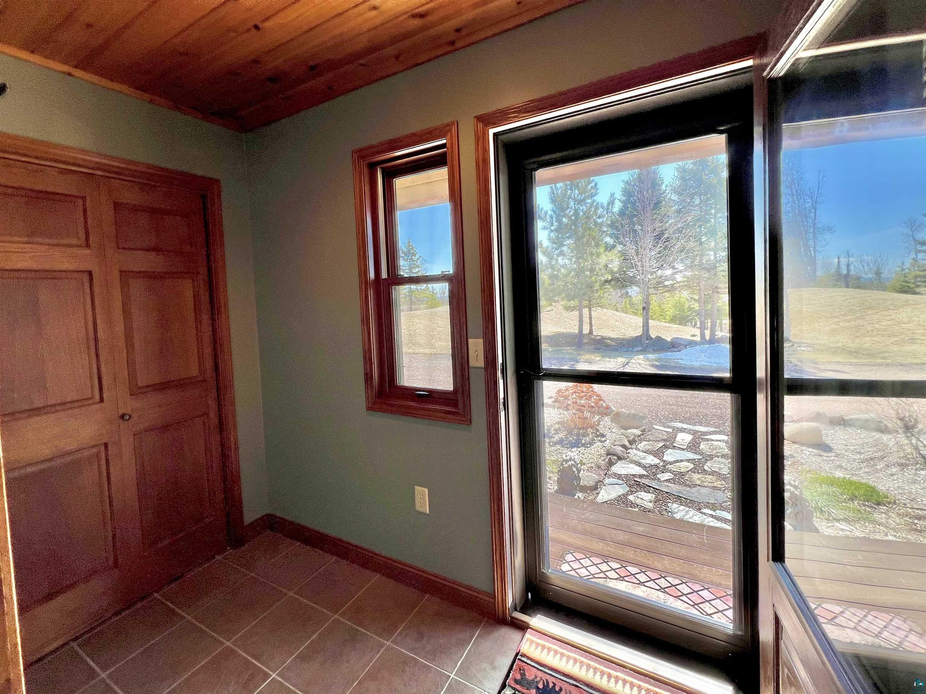 21 Turnagain Trail Lutsen, MN 55612 - Photo 23 of 77 Entryway featuring a wood-panel ceiling, warm-toned wall paint, and durable tile flooring
