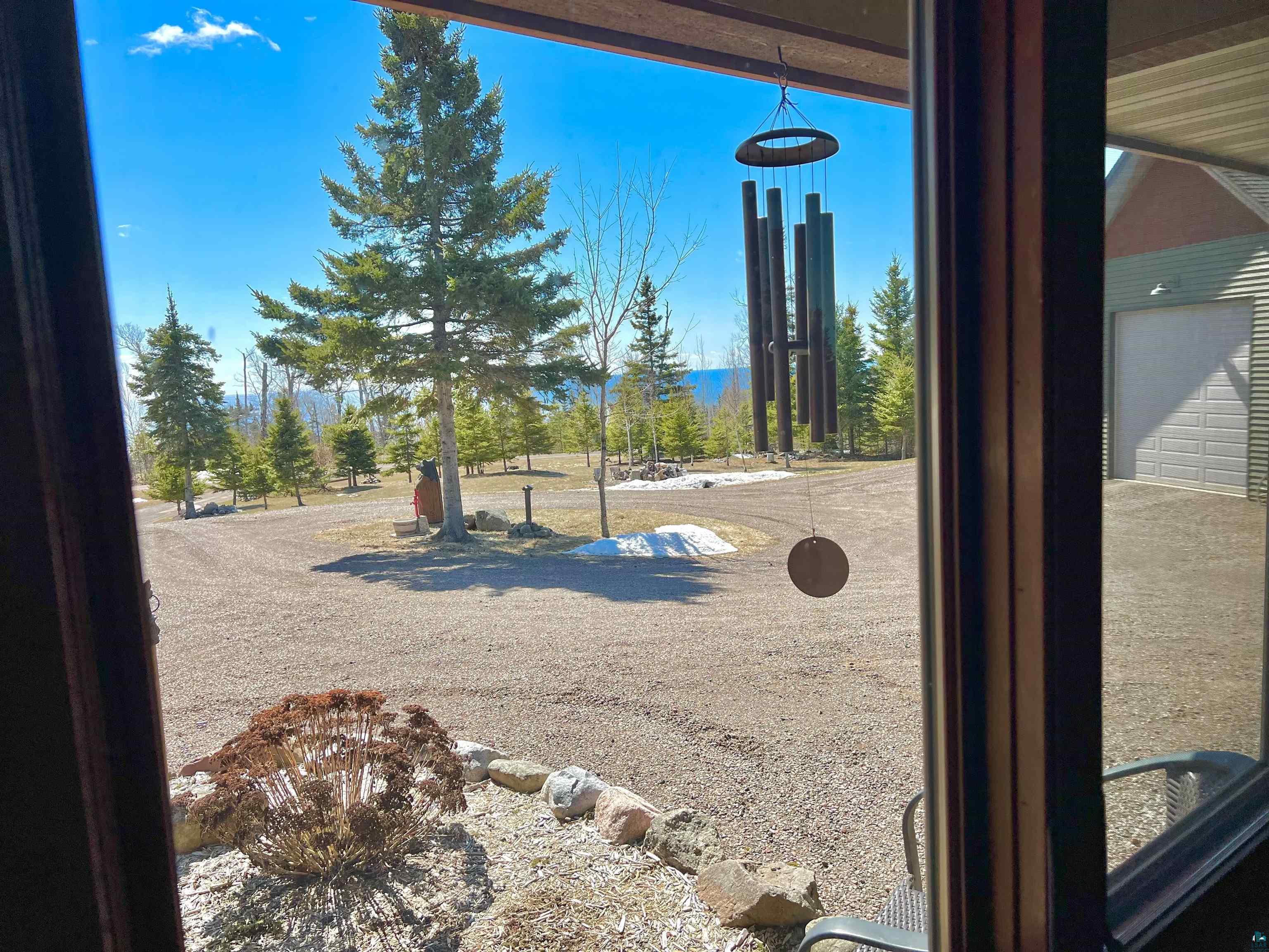 21 Turnagain Trail Lutsen, MN 55612 - Photo 26 of 77 Expansive gravel driveway with a large garage, surrounded by mature evergreen trees