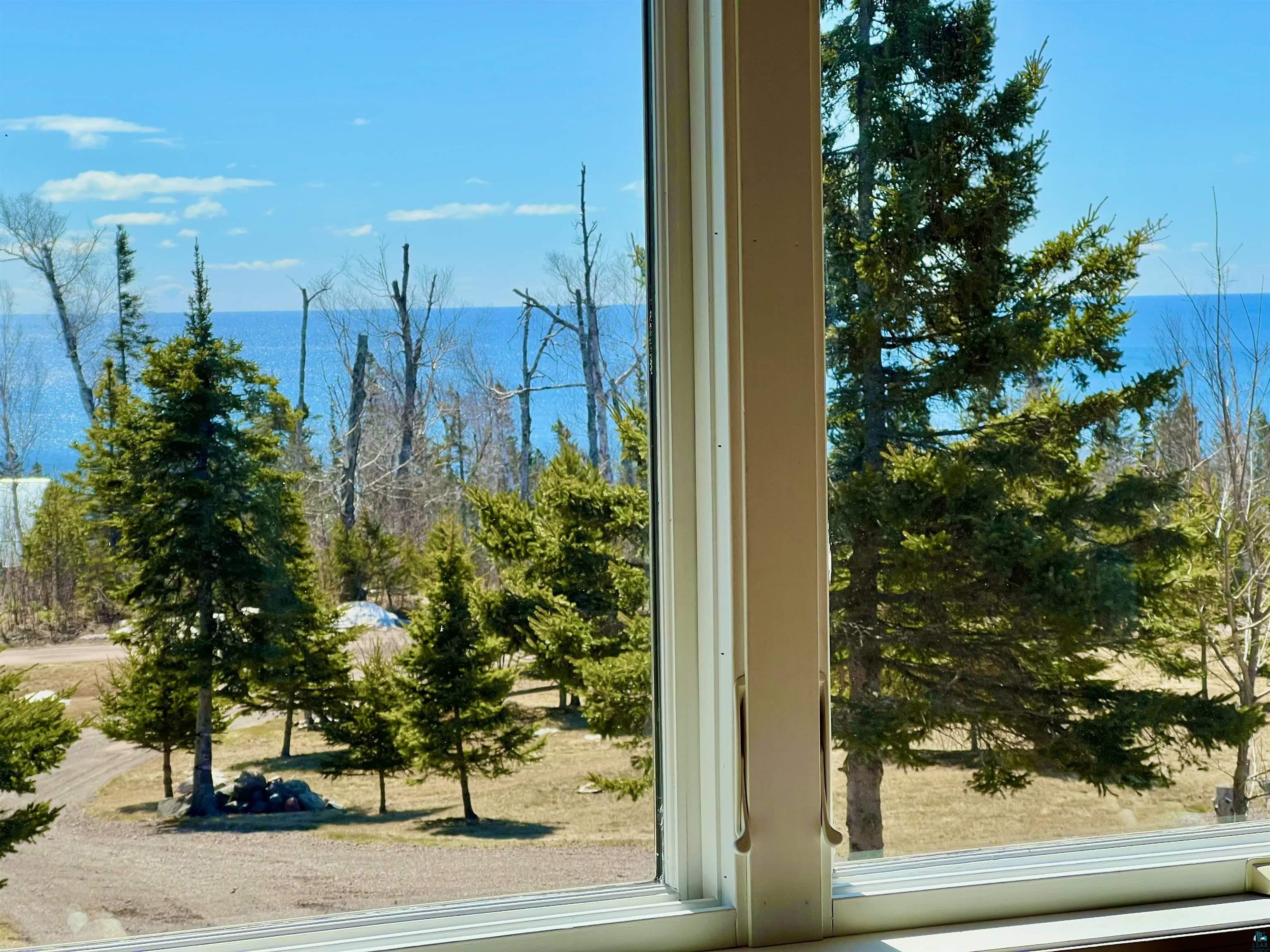 21 Turnagain Trail Lutsen, MN 55612 - Photo 3 of 77 Expansive window offering a broad landscape with mature evergreen trees, visible body of water, and natural light