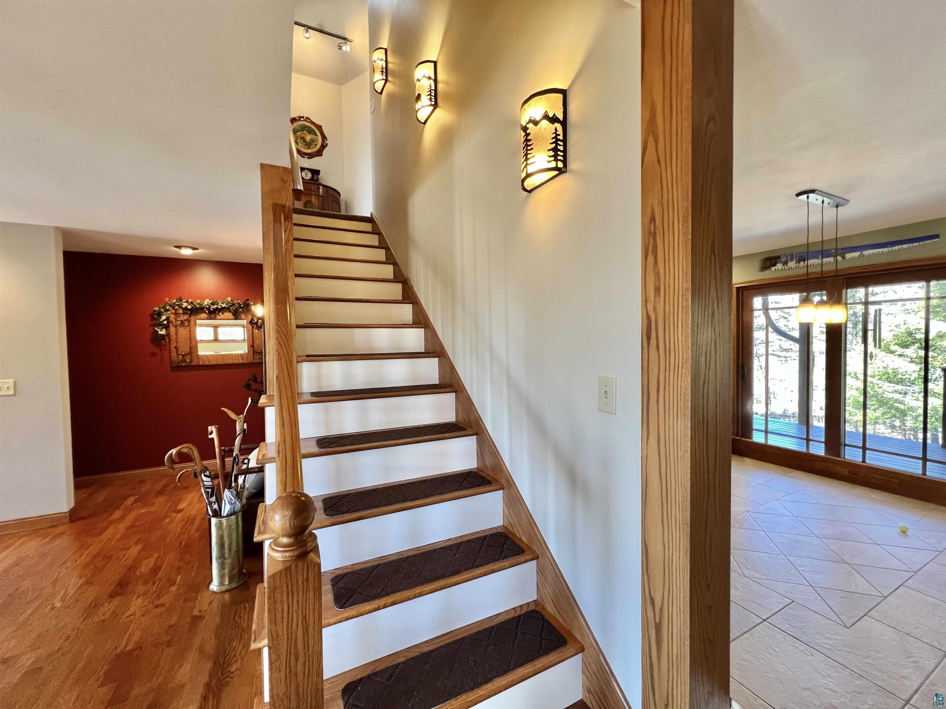 21 Turnagain Trail Lutsen, MN 55612 - Photo 31 of 77 Hardwood staircase with white risers and decorative wall sconces