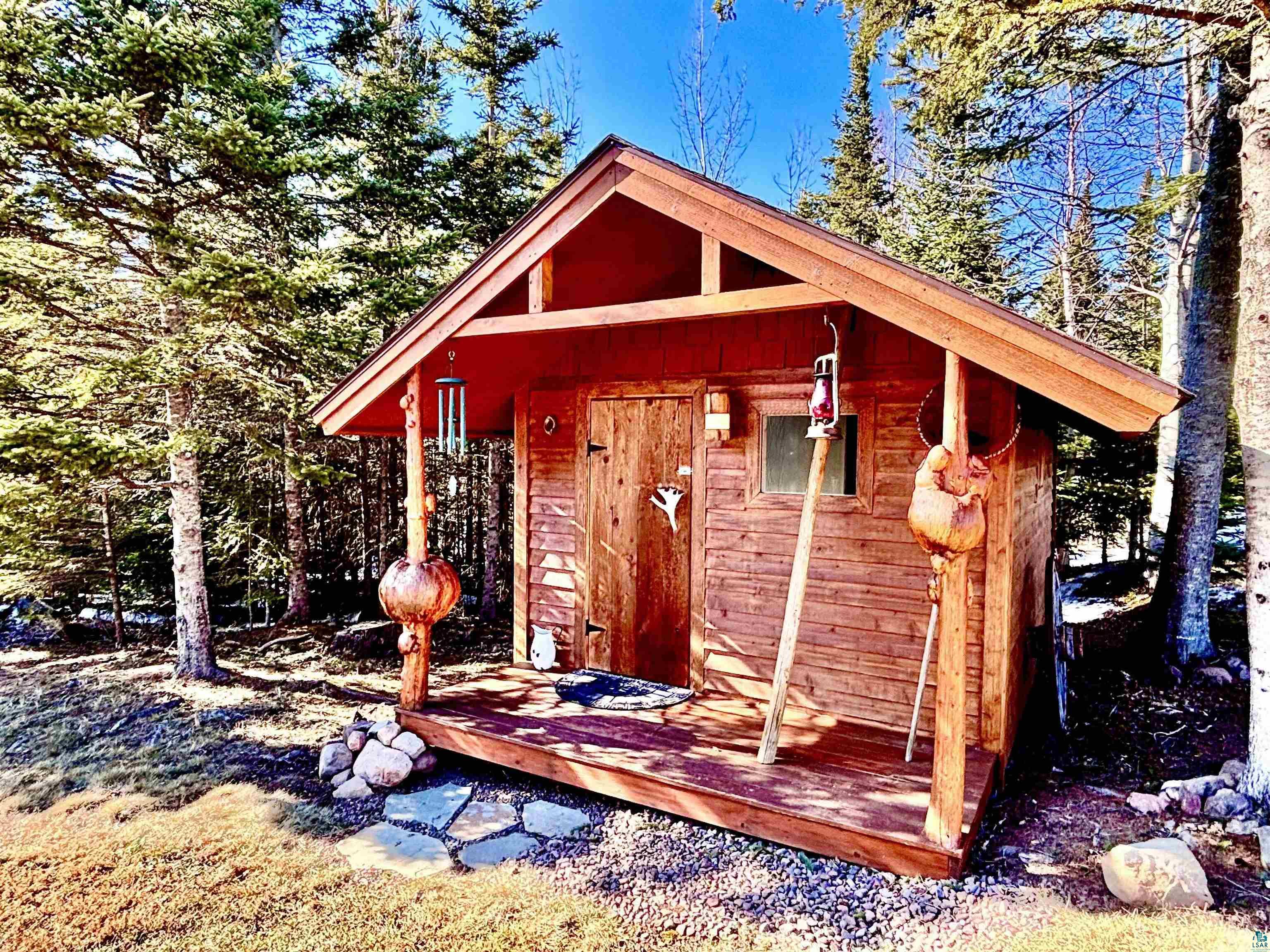 21 Turnagain Trail Lutsen, MN 55612 - Photo 44 of 77 Wood-sided outbuilding featuring a covered porch, clear paned window, and a gabled roof with red soffit