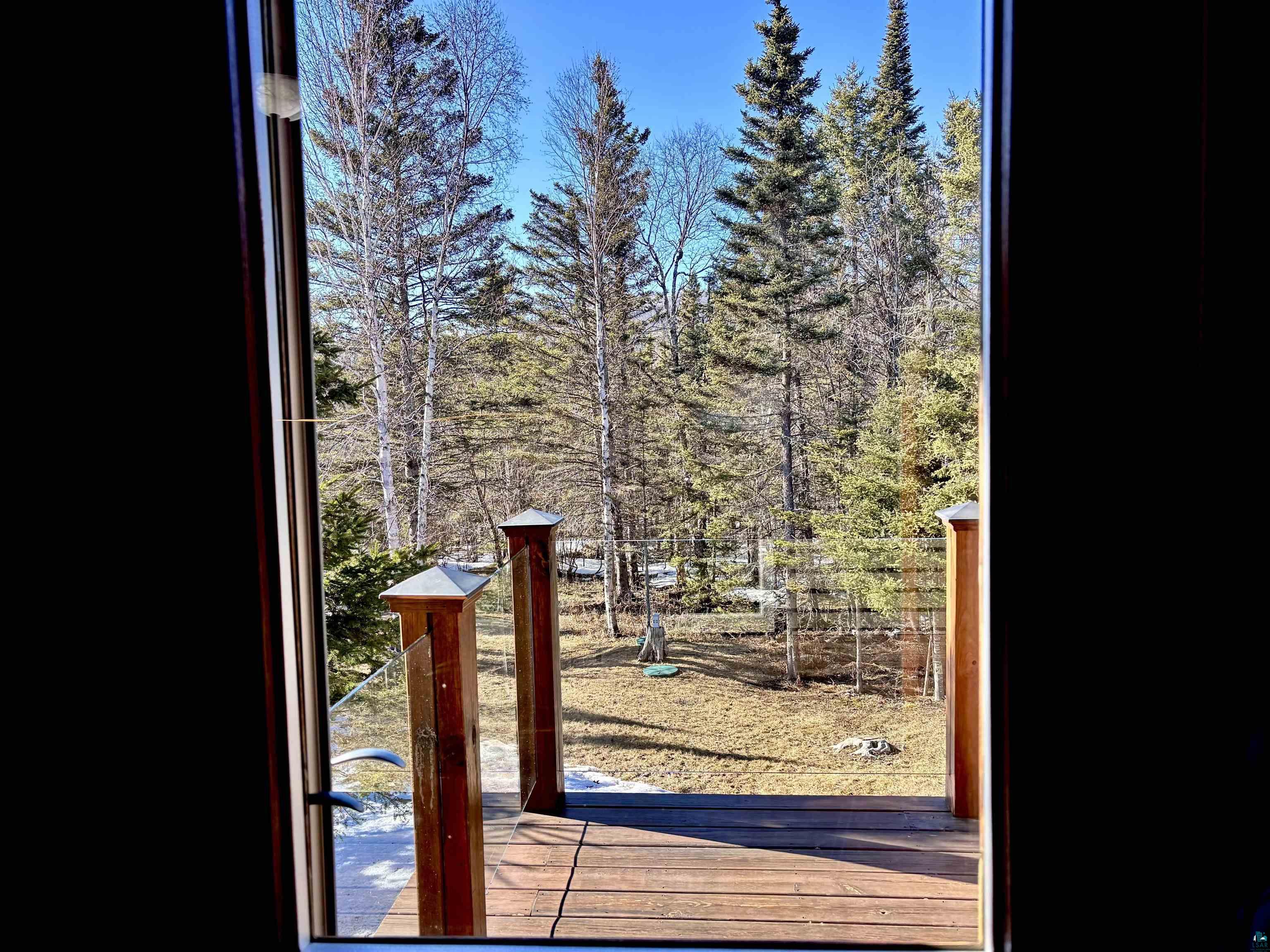 21 Turnagain Trail Lutsen, MN 55612 - Photo 48 of 77 Outdoor deck with wood planks, glass railing, and wood posts