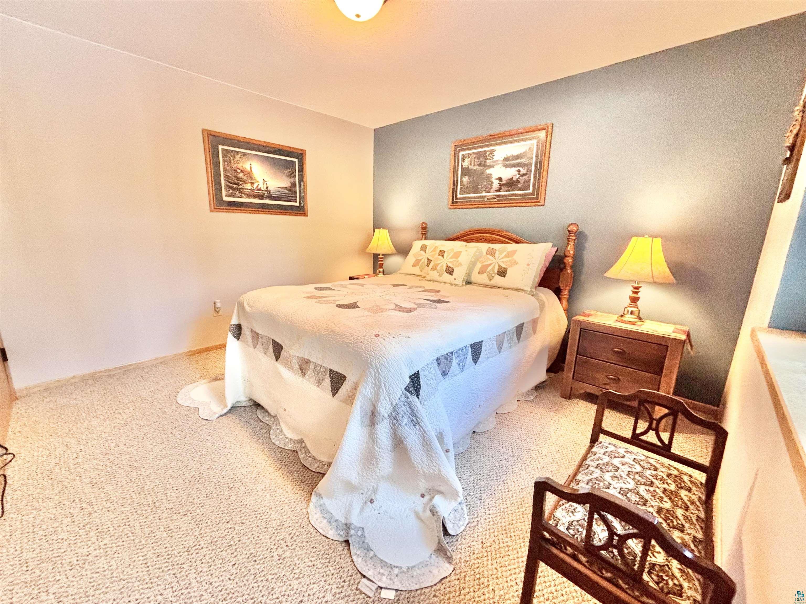 21 Turnagain Trail Lutsen, MN 55612 - Photo 58 of 77 Bedroom featuring light-colored carpet flooring and a two-tone wall treatment with a light neutral and a muted blue accent wall