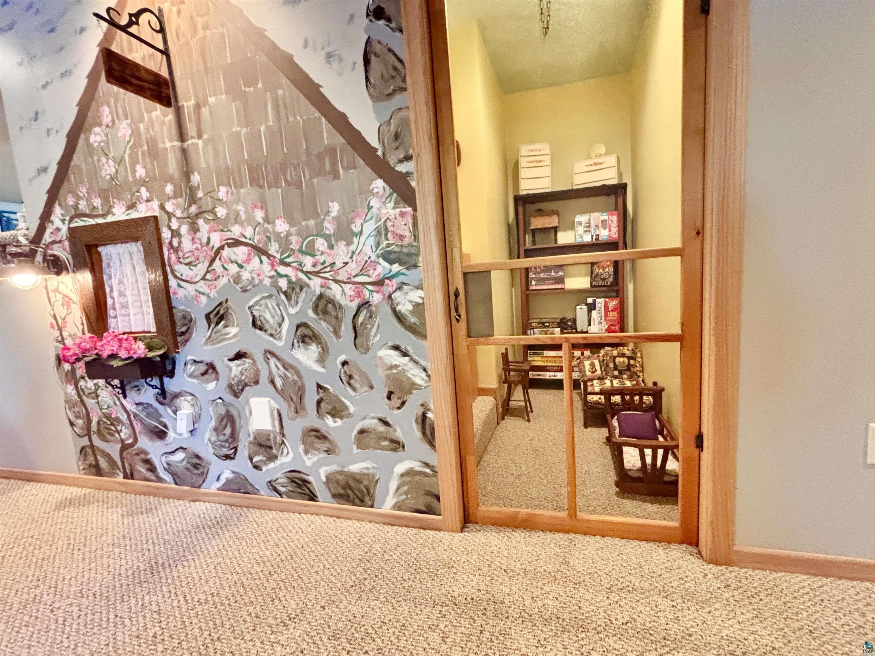 21 Turnagain Trail Lutsen, MN 55612 - Photo 65 of 77 Custom painted wall mural featuring a stone and shingle cottage design with floral accents