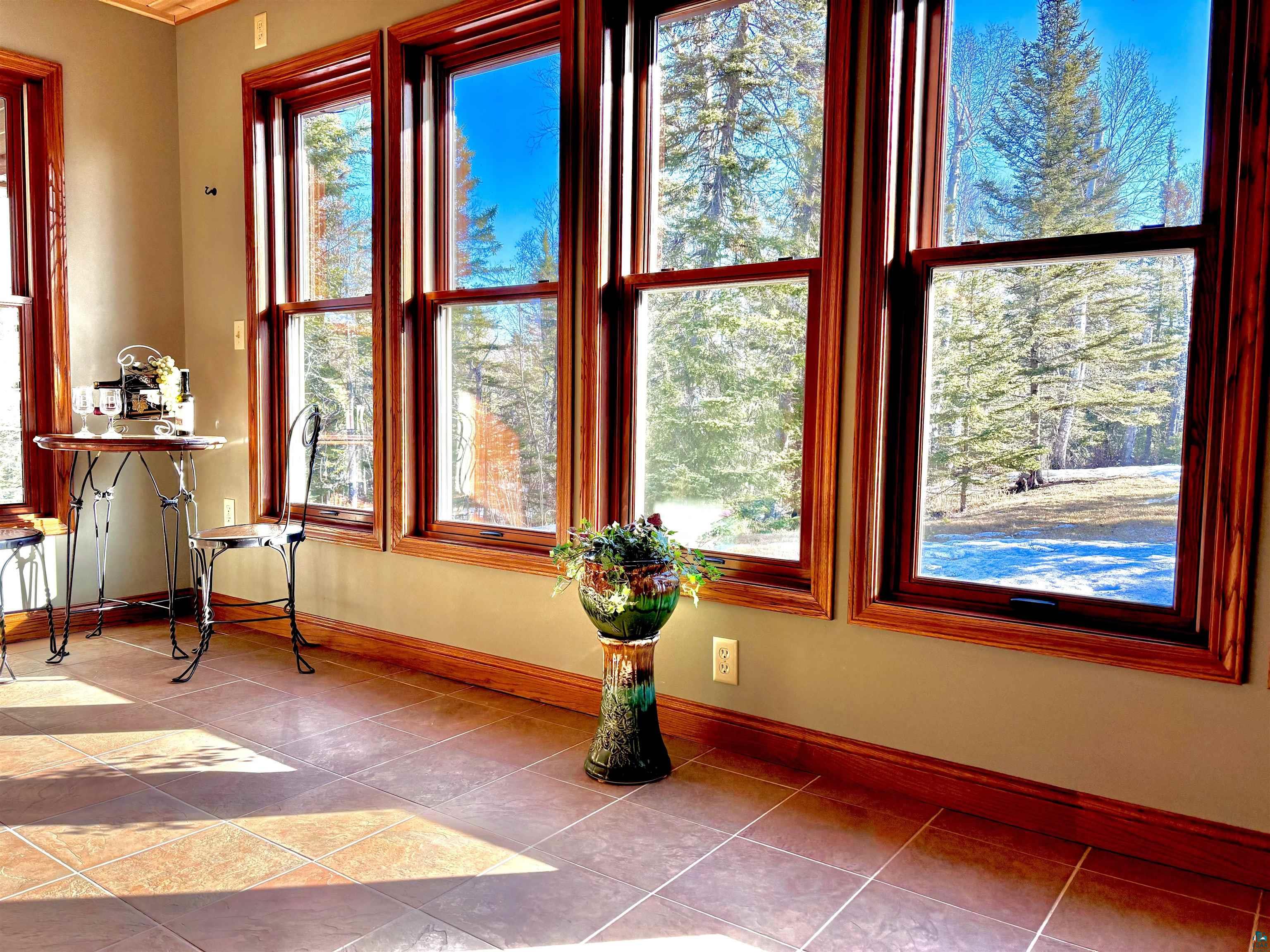 21 Turnagain Trail Lutsen, MN 55612 - Photo 7 of 77 Expansive windows with rich wood trim, tile flooring, and light green walls