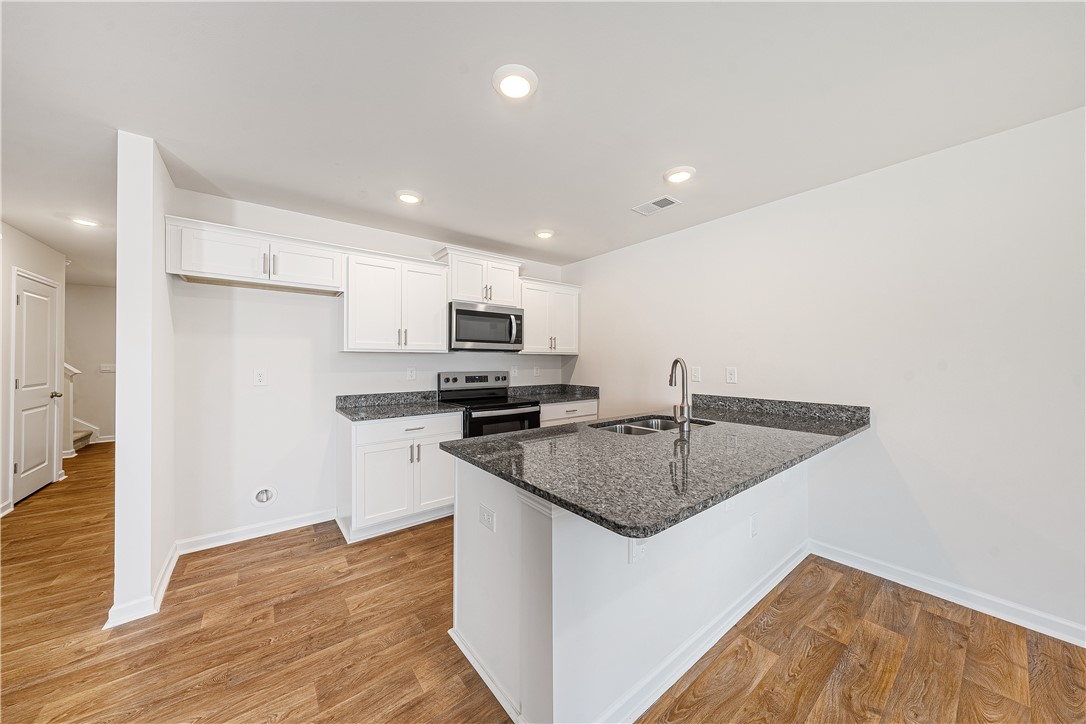 404 Oakmont Valley Trail Seneca, SC 29678 - Photo 12 of 44 This bright kitchen features durable flooring and sleek countertops, perfect for everyday living.