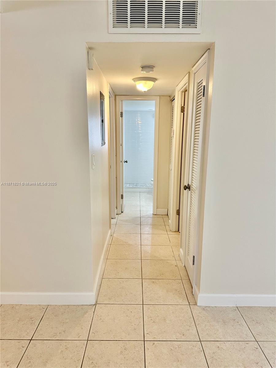 300 Northeast 12th Avenue, Unit 101 Hallandale Beach, FL 33009 - Photo 13 of 23 a view of a hallway with wooden floor and a bathroom