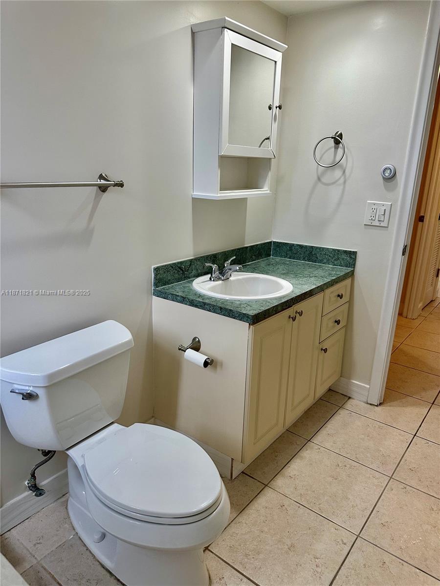 300 Northeast 12th Avenue, Unit 101 Hallandale Beach, FL 33009 - Photo 15 of 23 a bathroom with a granite countertop toilet and a sink