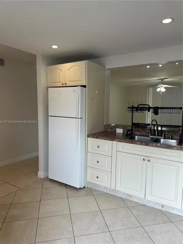 a kitchen with a refrigerator sink and cabinets