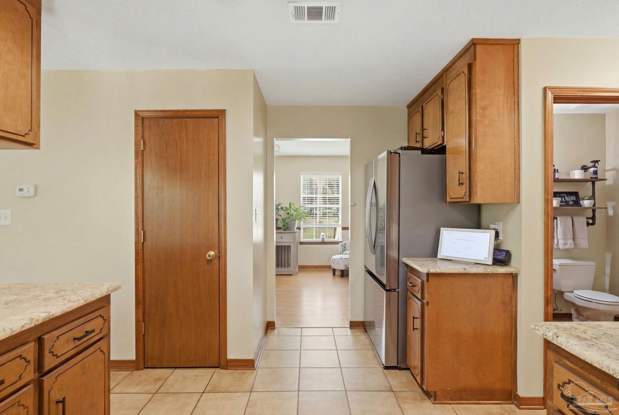 6870 Martin Road Milton, FL 32570 - Photo 14 of 48 a kitchen with a refrigerator a stove top oven and cabinets