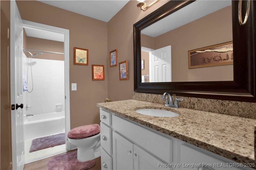 2375 Raeford Road Fayetteville, NC 28305 - Photo 20 of 39 a bathroom with a granite countertop sink mirror vanity bathtub and toilet