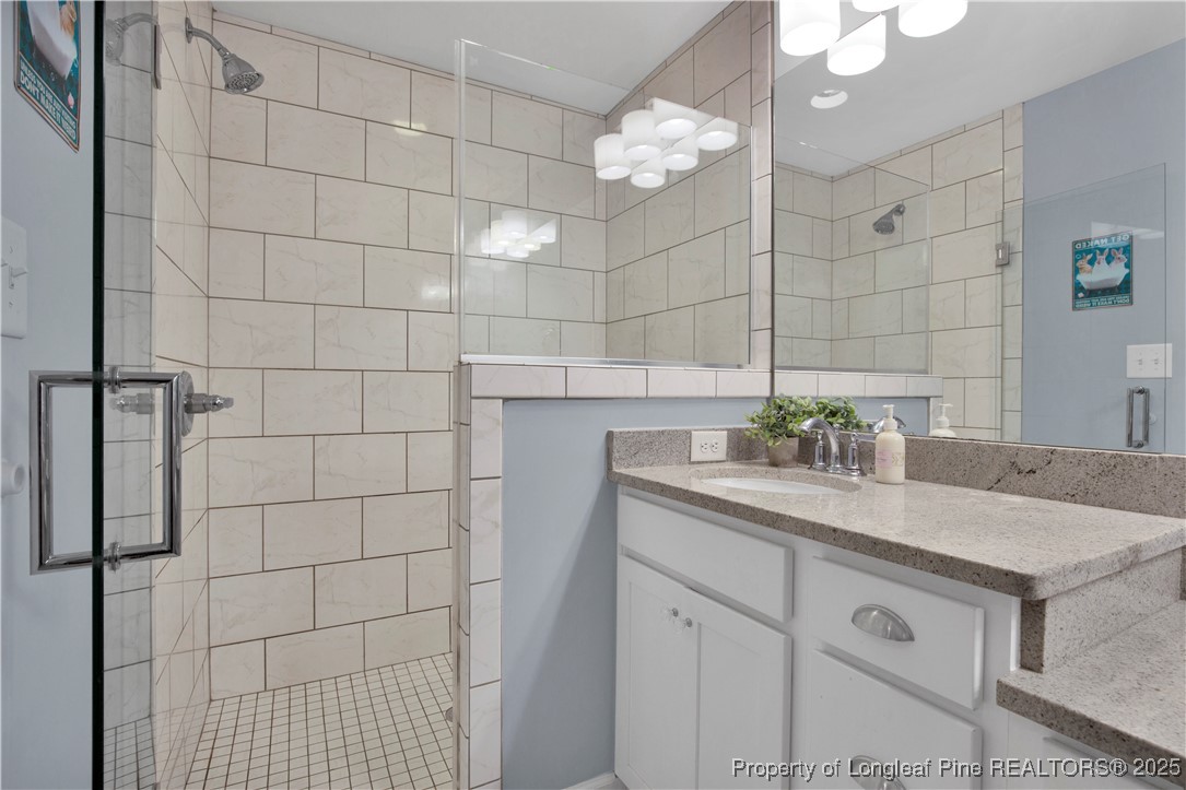 2375 Raeford Road Fayetteville, NC 28305 - Photo 27 of 39 a bathroom with a granite countertop shower a sink and a mirror