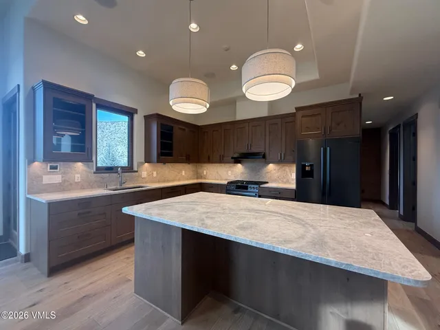 a large kitchen with stainless steel appliances a large counter top