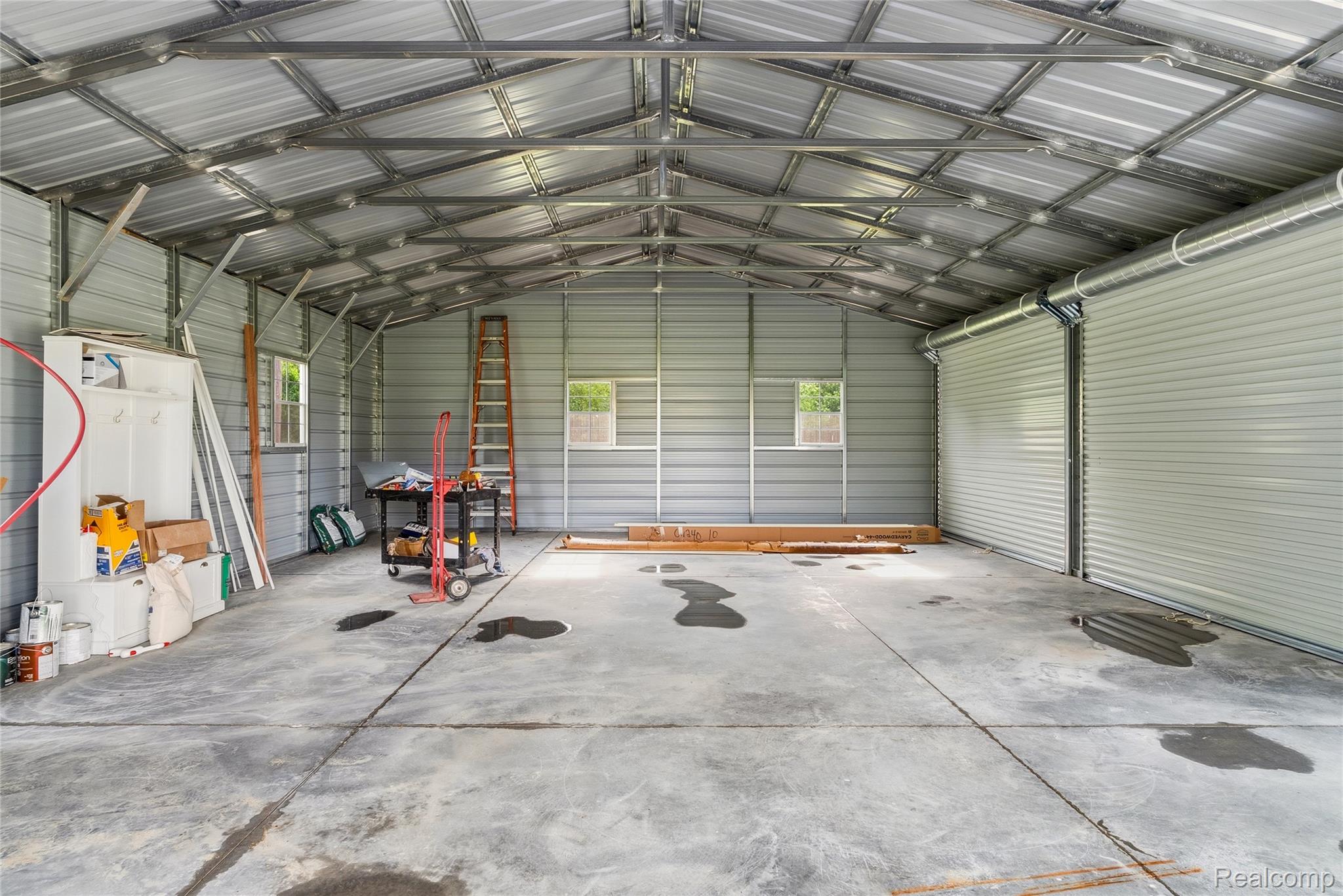 3241 East Frances Road Clio, MI 48420 - Photo 24 of 32 Spacious metal garage structure featuring a concrete floor, two roll-up doors, and two windows providing natural light