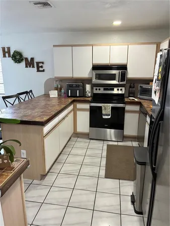 a kitchen with stainless steel appliances granite countertop a refrigerator sink and cabinets