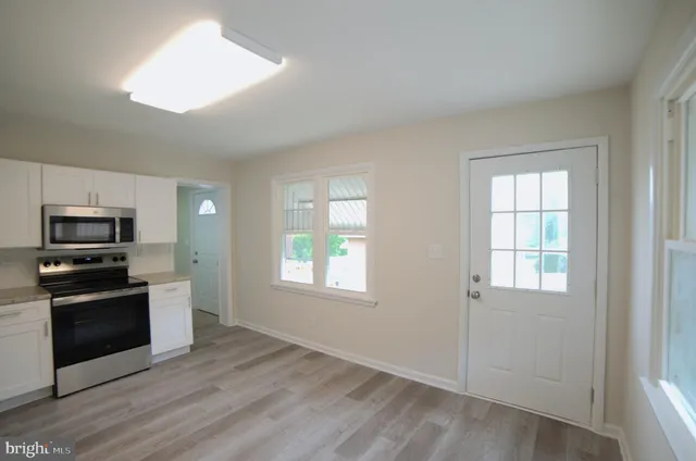 an empty room with windows and a fireplace