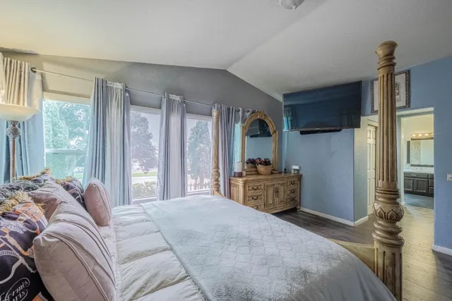 a bedroom with a bed and a flat screen tv