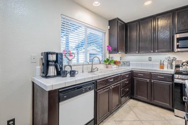 a kitchen with stainless steel appliances granite countertop a sink stove and cabinets