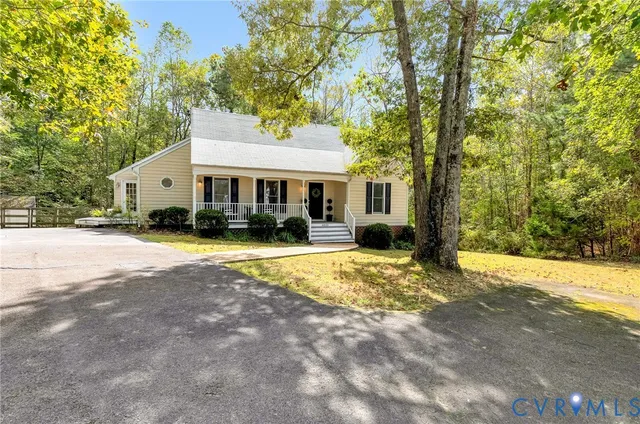 a view of a white house with a large tree