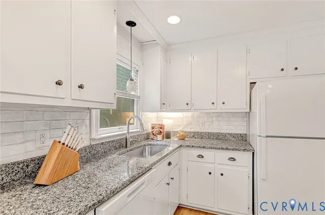 a kitchen with granite countertop white cabinets and white appliances