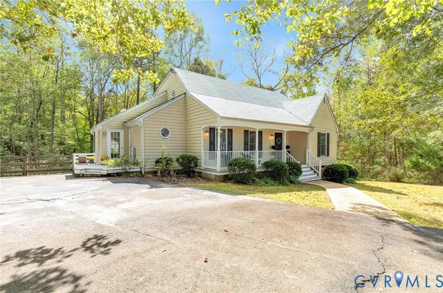 a view of a house with a yard and large trees