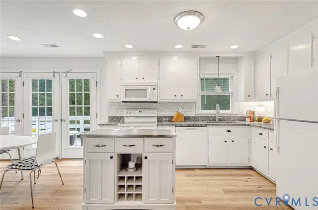 a kitchen with granite countertop white cabinets and white appliances